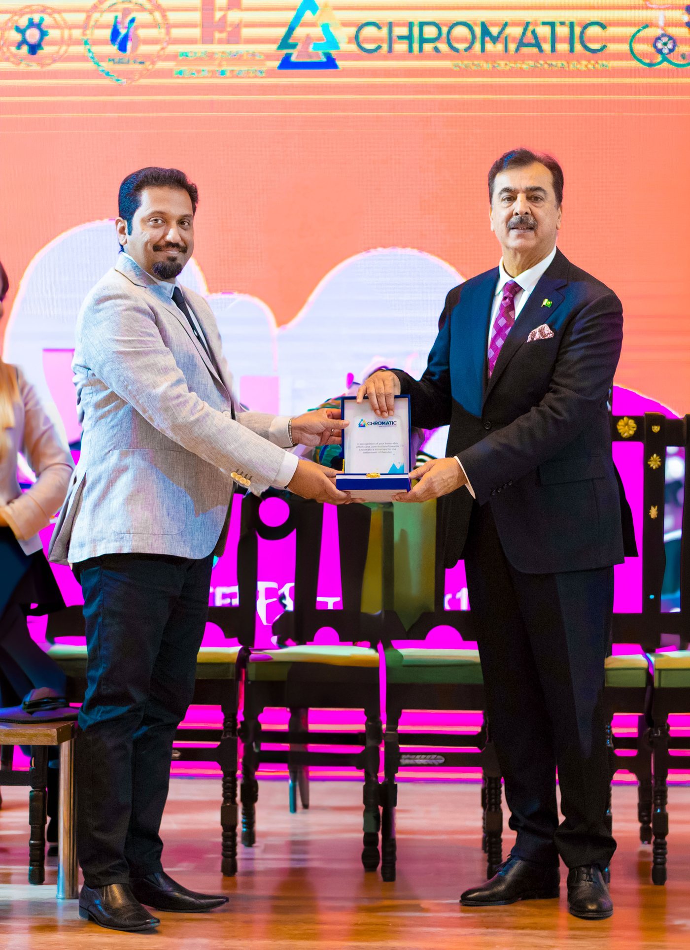 Yousaf Raza Gilani receiving the Chromatic recognition shield on a Chromatic-branded stage